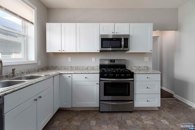 kitchen featuring sink, white cabinets, and appliances with stainless steel finishes