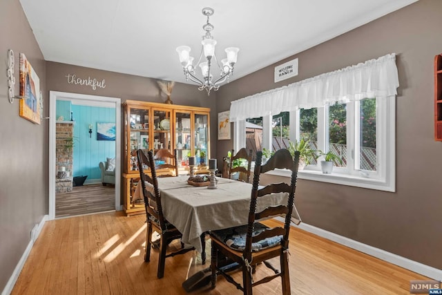 dining space featuring a notable chandelier and light hardwood / wood-style flooring