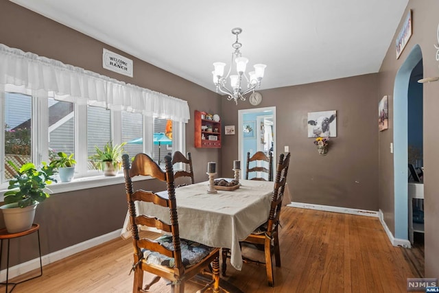 dining area featuring light hardwood / wood-style floors, a wealth of natural light, and a chandelier