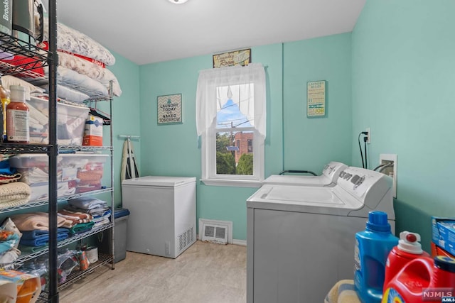 laundry area featuring light hardwood / wood-style floors and washing machine and dryer