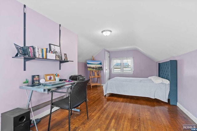 bedroom with wood-type flooring and vaulted ceiling