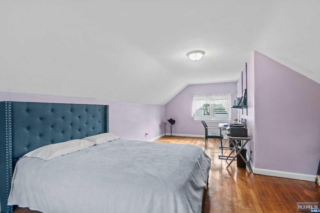 bedroom featuring hardwood / wood-style flooring and vaulted ceiling