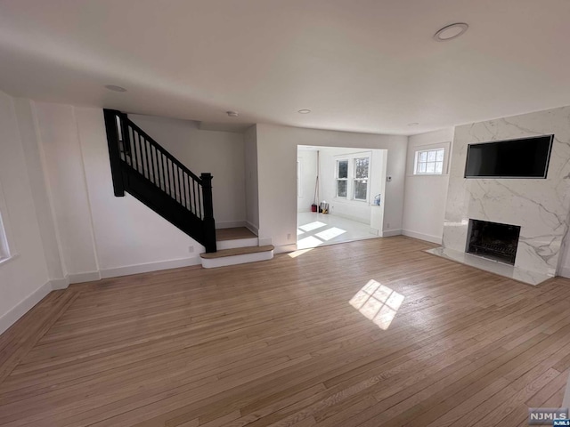 unfurnished living room with a premium fireplace and light hardwood / wood-style flooring