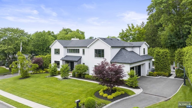 view of front of property featuring a front yard and a garage