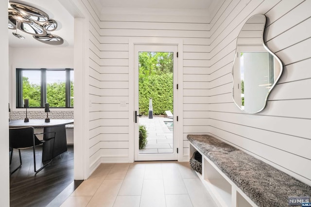 interior space featuring plenty of natural light, light wood-type flooring, and wooden walls