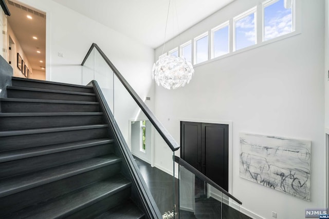 stairs with a notable chandelier