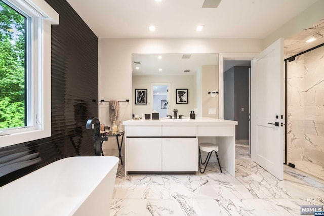 bathroom with vanity and shower with separate bathtub