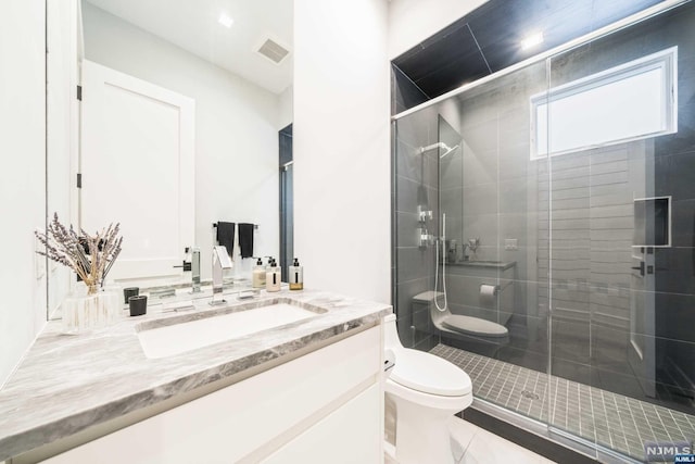 bathroom featuring tile patterned flooring, vanity, toilet, and an enclosed shower