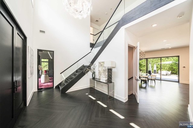 interior space with dark parquet floors and an inviting chandelier