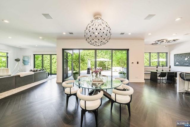 dining space featuring dark parquet flooring