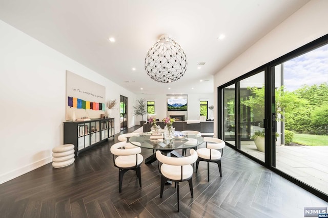 dining area with dark parquet floors and a chandelier