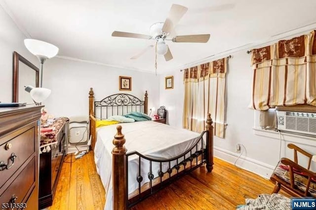 bedroom with hardwood / wood-style floors, ceiling fan, cooling unit, and ornamental molding