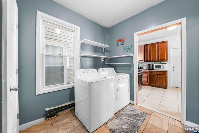 washroom with washing machine and dryer and light tile patterned floors