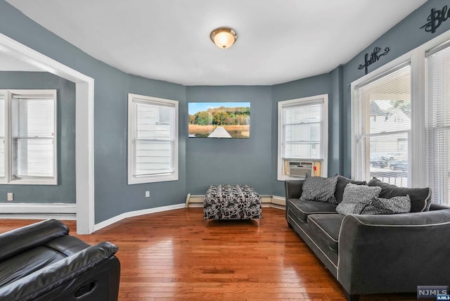 living room with baseboard heating, cooling unit, and hardwood / wood-style flooring