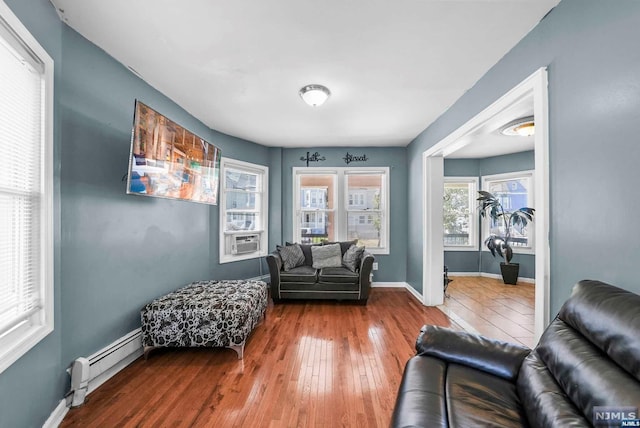 sitting room featuring hardwood / wood-style flooring and a baseboard heating unit