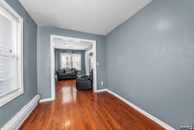 hall featuring hardwood / wood-style flooring and baseboard heating