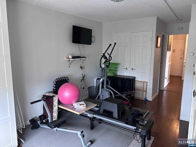 exercise room with hardwood / wood-style flooring and a textured ceiling