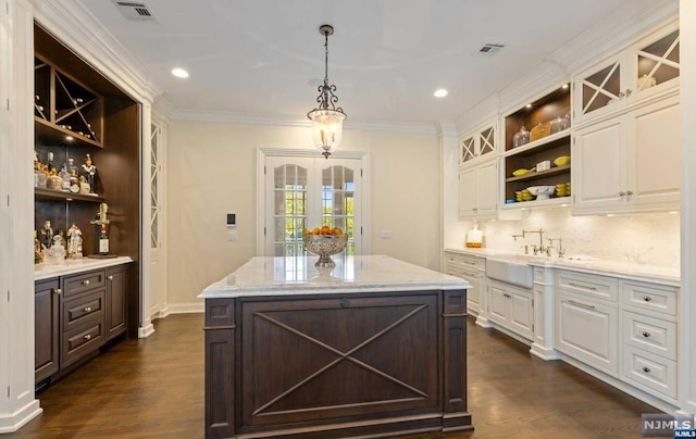 kitchen featuring white cabinets, sink, a kitchen island, and dark hardwood / wood-style flooring