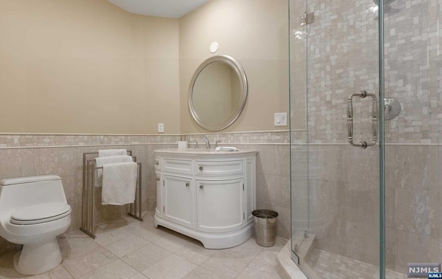 bathroom featuring tile patterned floors, a shower with door, tile walls, and toilet