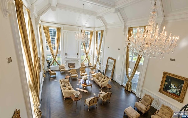 dining room with beam ceiling, ornamental molding, dark wood-type flooring, and an inviting chandelier