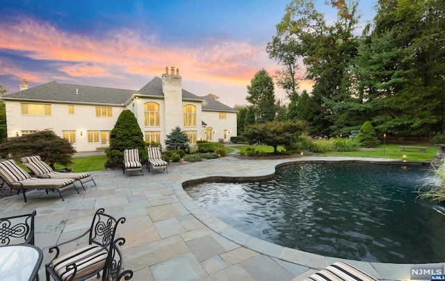 pool at dusk with a patio