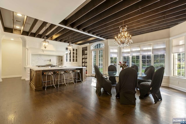 dining area with beamed ceiling, dark hardwood / wood-style floors, and an inviting chandelier