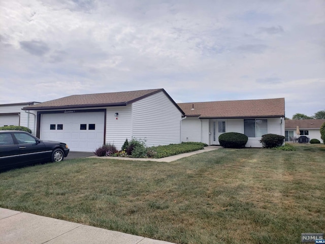 ranch-style home with a garage and a front lawn