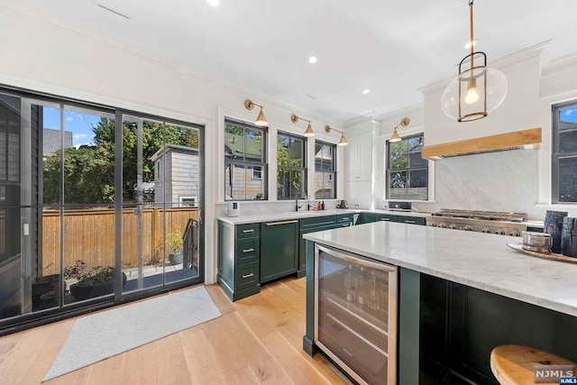 kitchen featuring wine cooler, plenty of natural light, green cabinets, and pendant lighting