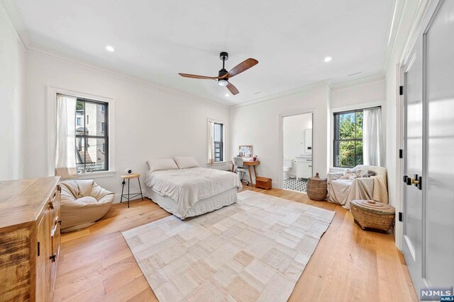 bedroom with connected bathroom, light hardwood / wood-style flooring, ceiling fan, and crown molding