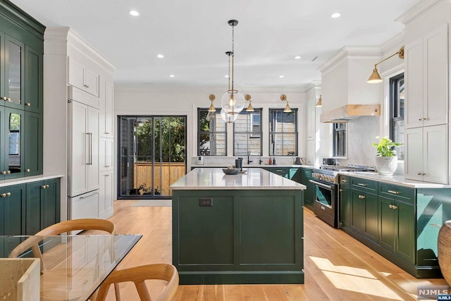 kitchen with custom range hood, light hardwood / wood-style flooring, high quality appliances, white cabinetry, and green cabinets