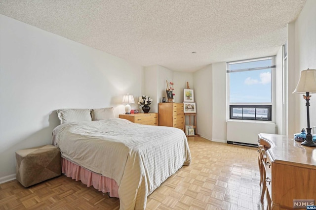 bedroom featuring radiator heating unit, a textured ceiling, and light parquet floors