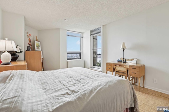 bedroom with light parquet floors and a textured ceiling