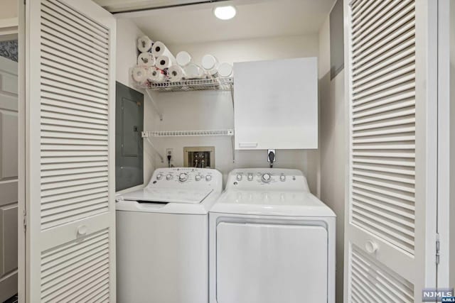 clothes washing area featuring electric panel and separate washer and dryer