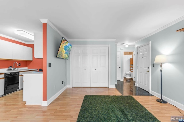 kitchen with ornamental molding, white cabinets, light wood-type flooring, and black dishwasher