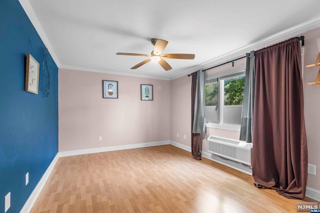 spare room with ceiling fan, wood-type flooring, ornamental molding, and an AC wall unit