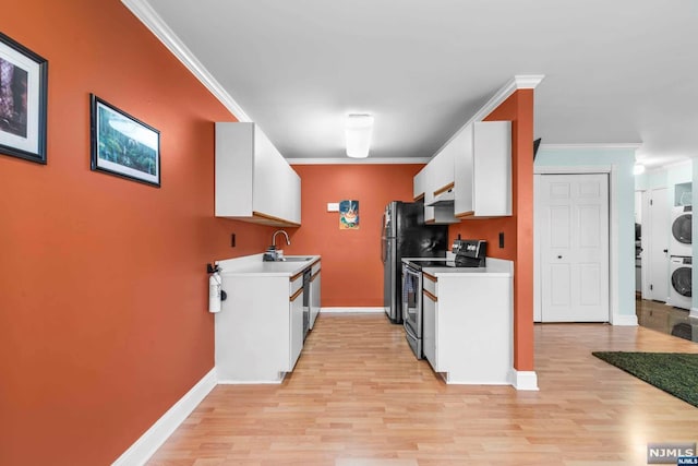 kitchen featuring white cabinets, light wood-type flooring, stacked washer and clothes dryer, and appliances with stainless steel finishes