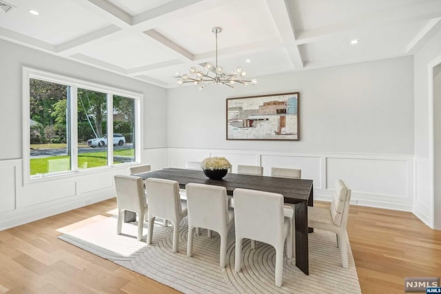 dining space featuring beam ceiling, a chandelier, coffered ceiling, and light wood-type flooring