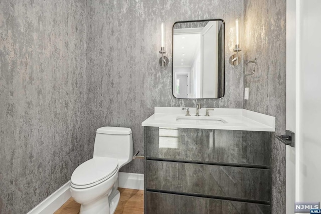 bathroom with vanity, toilet, and wood-type flooring