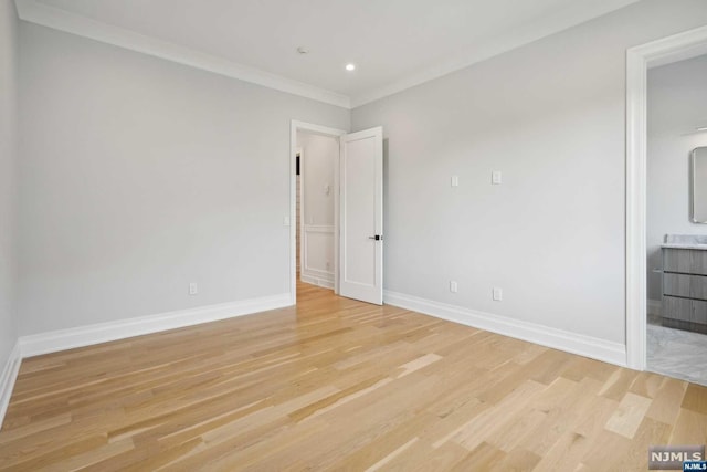 empty room featuring crown molding and light wood-type flooring