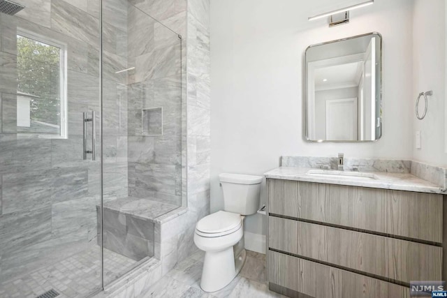 bathroom featuring vanity, toilet, and walk in shower