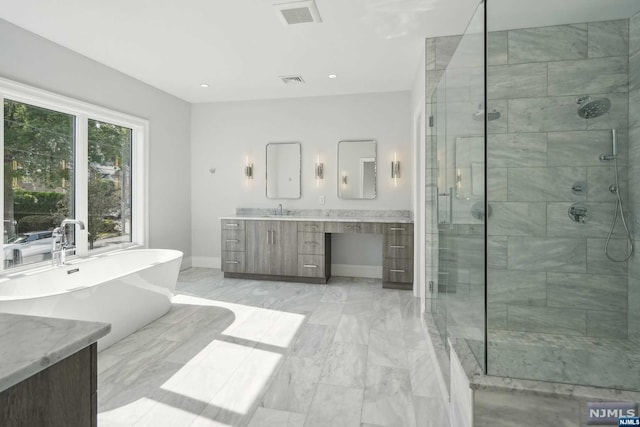 bathroom featuring vanity and independent shower and bath