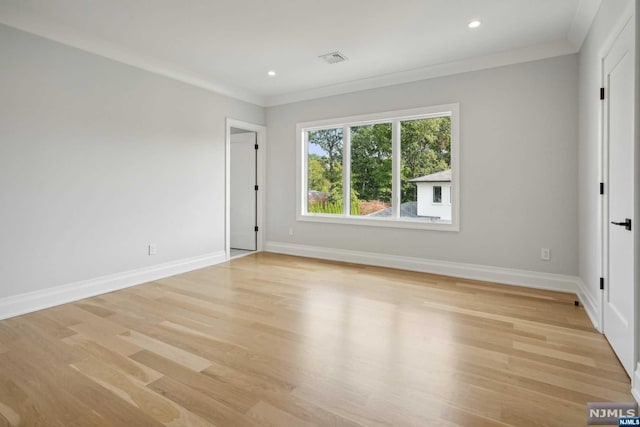 spare room featuring light wood-type flooring and ornamental molding