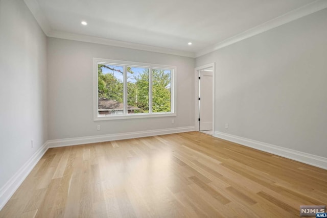 spare room with light wood-type flooring and ornamental molding