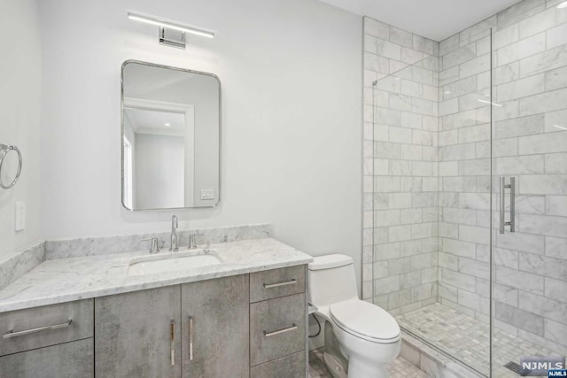 bathroom with vanity, toilet, and a shower with door