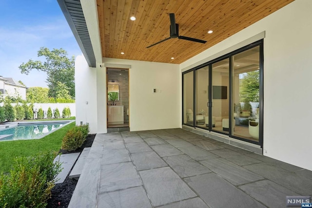 view of patio / terrace featuring ceiling fan and a fenced in pool