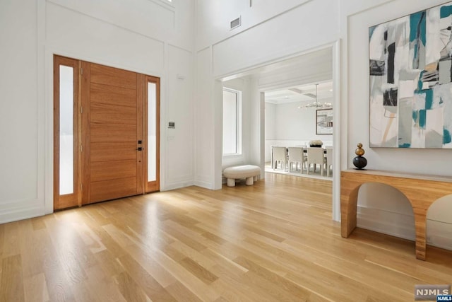 entrance foyer with hardwood / wood-style floors and a chandelier