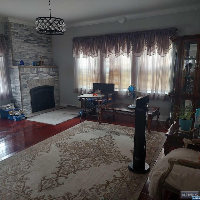 office with a stone fireplace, wood-type flooring, and ornamental molding