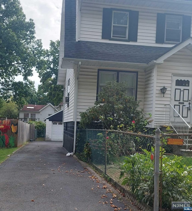 view of front of property with a garage and an outdoor structure