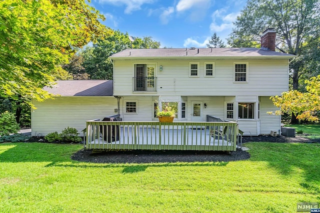 back of property with a yard, a wooden deck, and central air condition unit