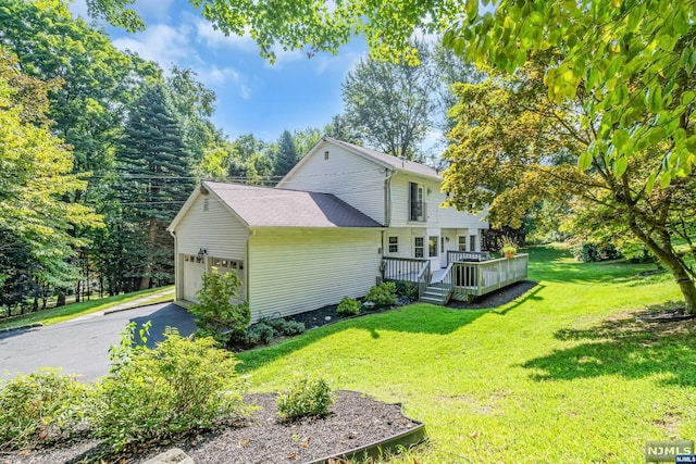 view of side of property with a lawn, a wooden deck, and a garage